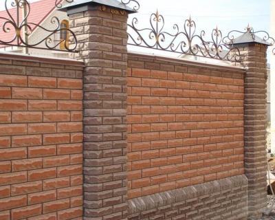 Сплошной забор из коричневого кирпича с навершиями