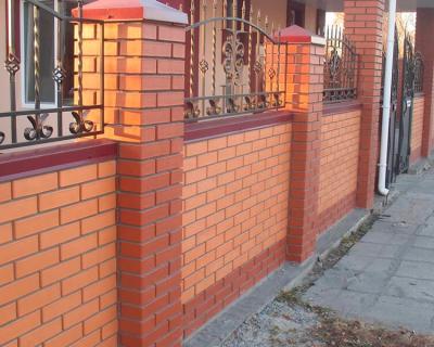 Сплошной забор из кирпича с навершиями