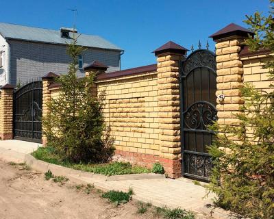 Кирпичный забор со столбами из декоративного камня