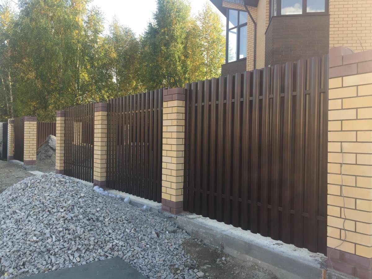 Забор из коричневого евроштакетника с кирпичными столбами