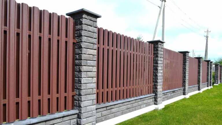 Забор из коричневого металлического штакетника с цоколем