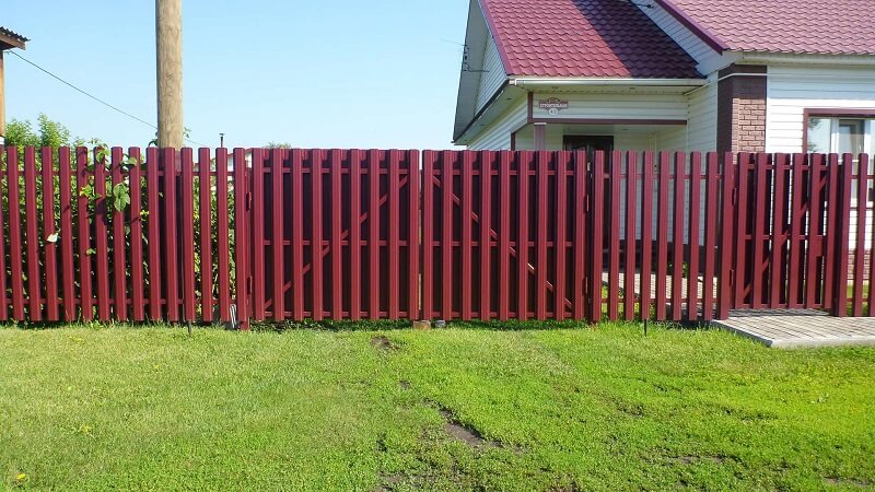 Забор из красного металлического штакетника для частного дома