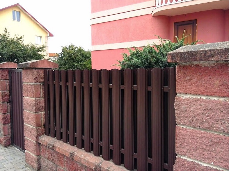 Забор из евроштакетника коричневый на каменных столбах